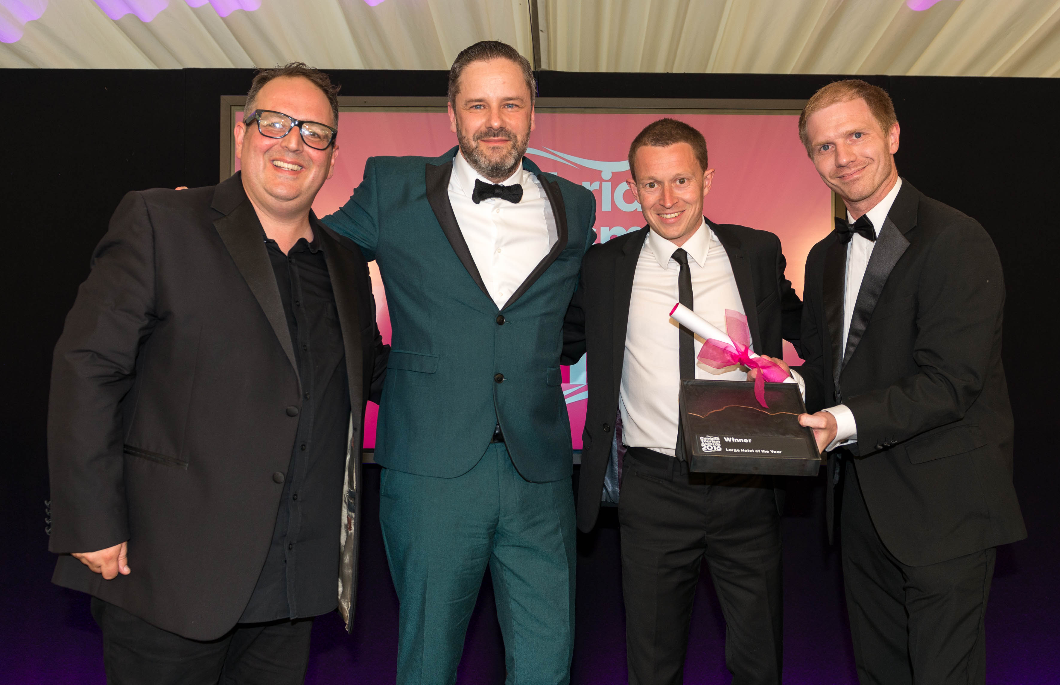 CUMBRIA TOURISM AWARDS 2016 --- Large Hotel of the Year winner - Waterhead Hotel, Ambleside. (l-r) Justin Moorhouse, Matt Stanaway, Anthony Sutcliffe, and award sponsor Richard Andrew of Armstrong Watson. // Annual award ceremony from Cumbria Tourism celebrating the best in the county's tourist attractions. Held at Cartmel Racecourse and hosted by comedian Justin Moorhouse. Wednesday 22nd June 2016. HARRY ATKINSON