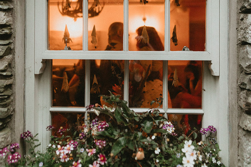 View from outside looking in through a window to a couple dancing.