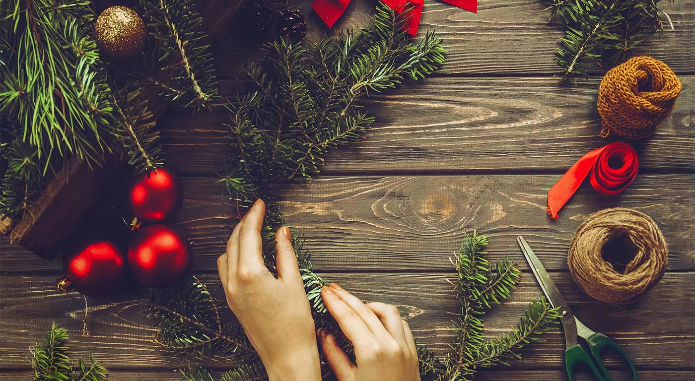 Foliage being shaped to form a decorative Christmas wreath.